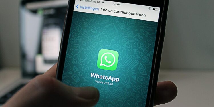 A smartphone displaying the WhatsApp application screen held by a person.